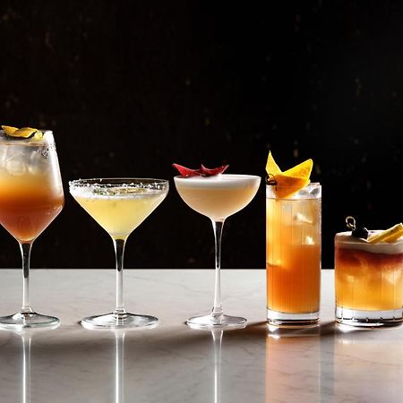 Middle Eight - Covent Garden - Preferred Hotels And Resorts Лондон Экстерьер фото The photo features a selection of five different cocktails lined up on a marble surface. Each drink is served in a distinct glass, showcasing a variety of colors and garnishes. 

1. The first cocktail is in a large wine glass, with a gradient color f