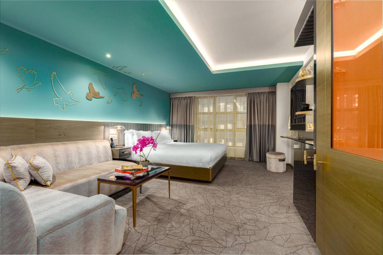 Middle Eight - Covent Garden - Preferred Hotels And Resorts Лондон Экстерьер фото The photo shows a modern hotel room featuring a blend of comfort and style. The room has a light-colored floor with a textured design, and the walls are adorned with a vibrant turquoise accent wall that features decorative butterfly motifs. 

There i