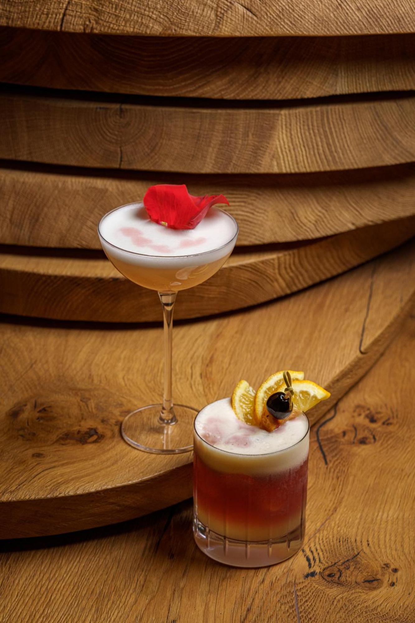 Middle Eight - Covent Garden - Preferred Hotels And Resorts Лондон Экстерьер фото The photo showcases two elegant cocktails arranged against a warm wooden backdrop. 

1. The first cocktail is served in a classic coupe glass. It has a frothy, pale hue, topped with a vibrant red flower petal, adding a touch of sophistication. 

2. T