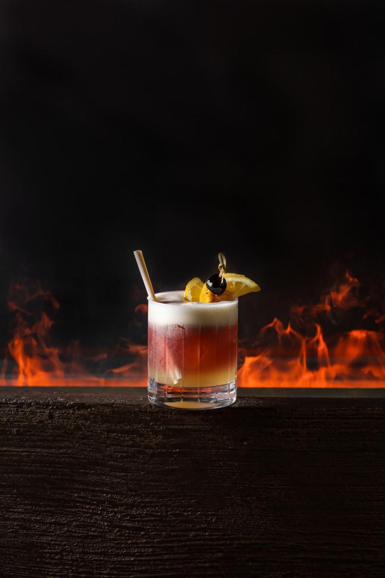 Middle Eight - Covent Garden - Preferred Hotels And Resorts Лондон Экстерьер фото The image shows a cocktail presented in a clear glass with a thick base. The drink features layered colors, transitioning from a deep reddish hue at the bottom to a lighter, frothy layer on top. It is garnished with a slice of lemon and a cherry, and